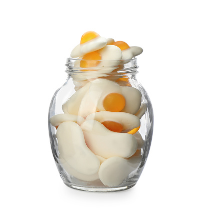 Jar with jelly candies in shape of egg on white background