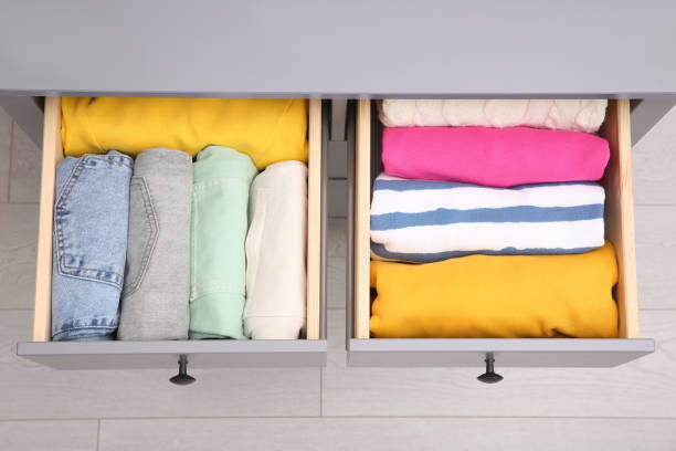 istock Open drawers with folded clothes indoors, top view. Vertical storage 1411574618