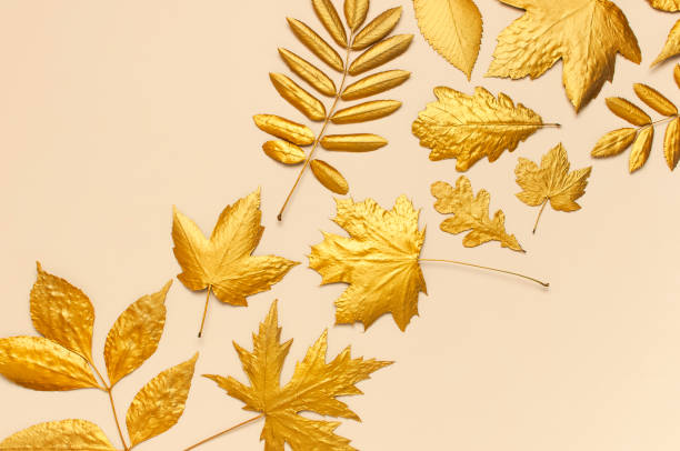 istock Flat lay creative autumn composition. Golden leaves on beige background top view copy space. Fall concept. Autumn background. Minimal concept idea, floral design 1411574792