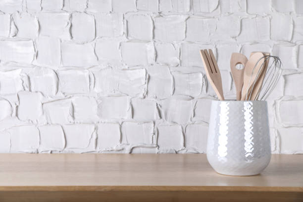 istock Holder with different kitchen utensils on wooden table. Space for text 1411575659