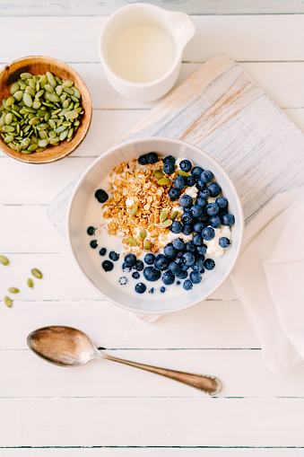 Curd cheese with granola, blueberries and pumpkin seeds in a bowl