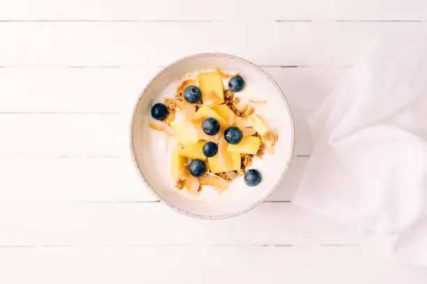 Curd cheese with granola, mango and blueberries in a bowl