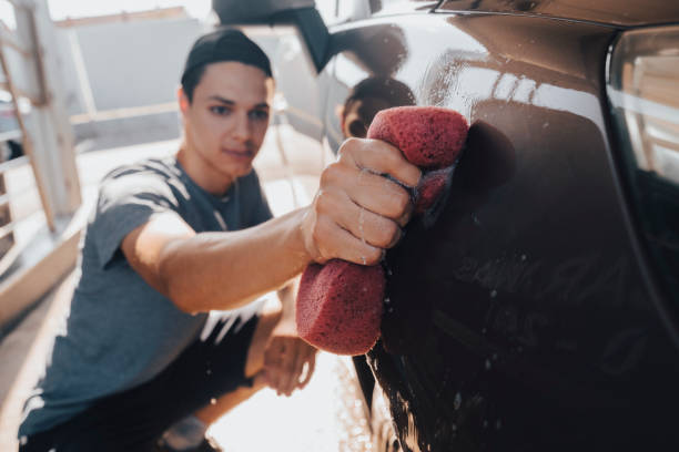istock Young man washing car 1411577696
