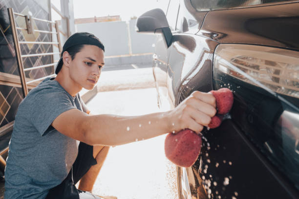 istock Young man washing car 1411578354