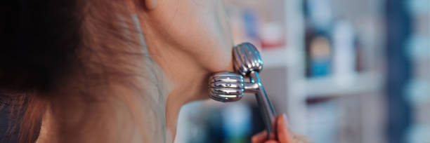 mujer joven usando rodillo facial para masaje facial. belleza cuidado de la piel - quartz caucasian one person energy fotografías e imágenes de stock