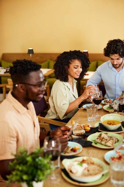 istock A group of multicultural friends eats dinner at the restaurant. 1411580114