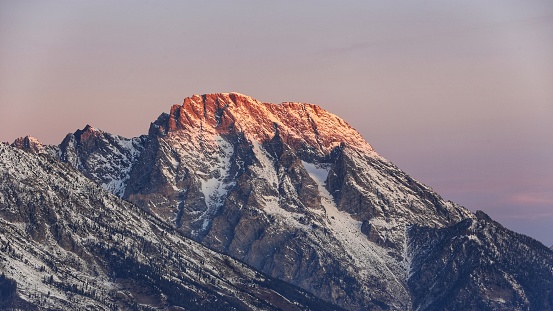 close up shot of morgenrot of Grand Teton mountain range during dawn time in winter at Glacier View Turnout
