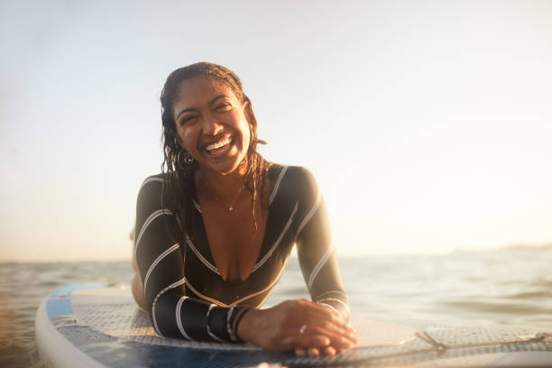 istock A woman floating on a paddleboard smile at the camera. 1411581390