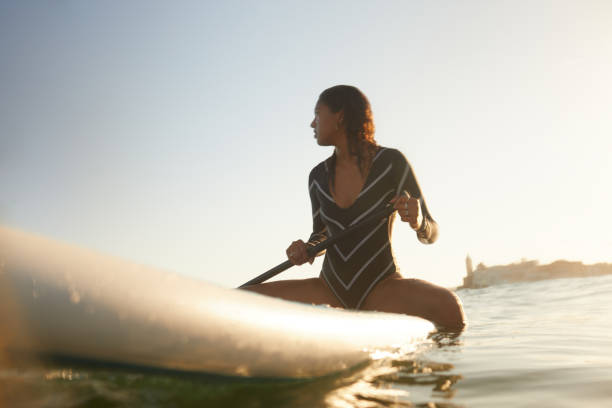 istock A woman is sitting and relaxing on a paddle surf board. 1411581547