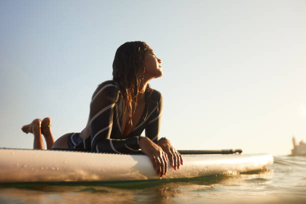 istock A woman is resting on a floating Paddle surfboard. 1411581652