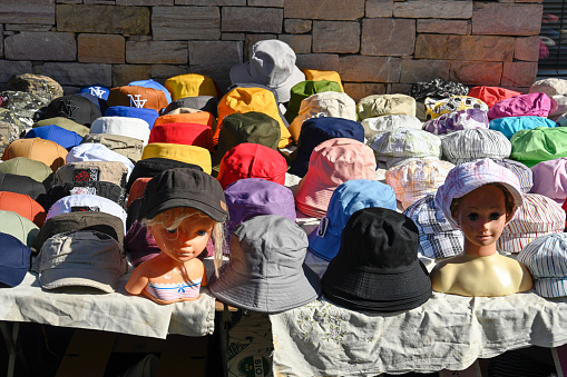 Erquy, France, July 2, 2022 - Hats and caps on a stall at the weekly market in the centre of Erquy, Brittany.