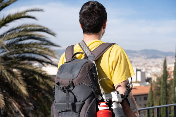 istock backpacker photographer unrecognizable looking at the cityscape during a trip. in sight his backpack, water bottle and camera. 1411593303