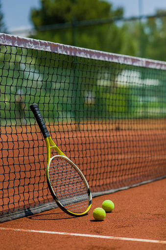 Outdoors tennis court with racket and balls