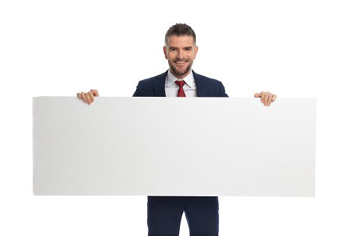 businessman feeling happy to present us his blank billboard against white background