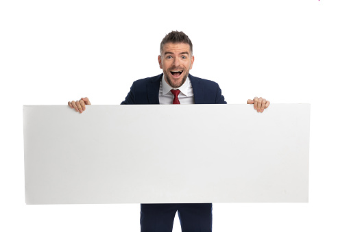 excited businessman presenting an horizontal billboard against white studio backgorund