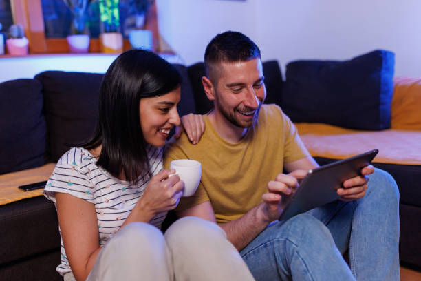 istock Young couple playing games on digital tablet 1411595131