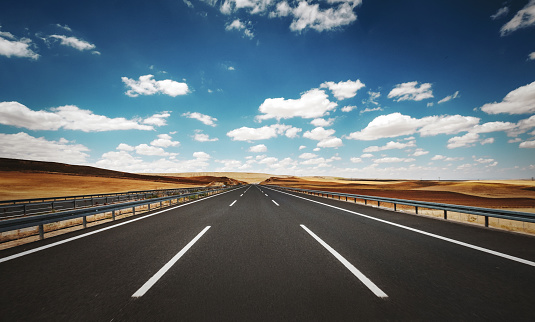 Empty road through the desert dunes with copy space