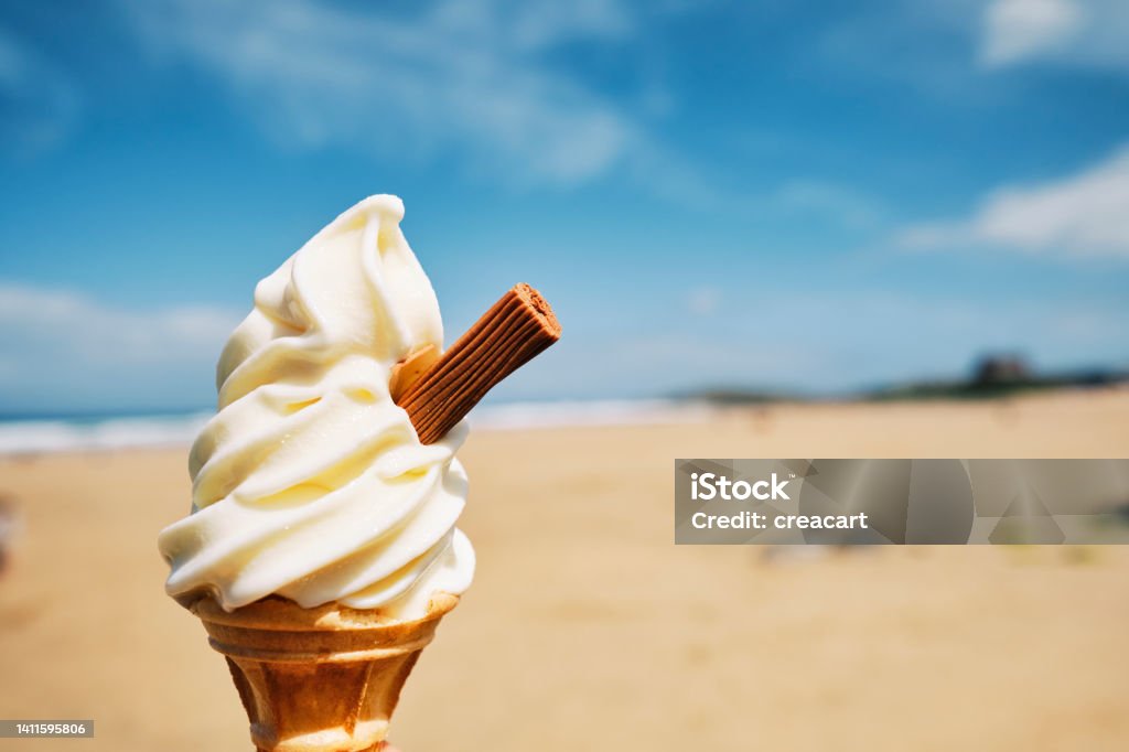 POV of an Ice cream cone overlooking Fistral Beach, Newquay, Cornwall on a sunny summers day. Beach Stock Photo
