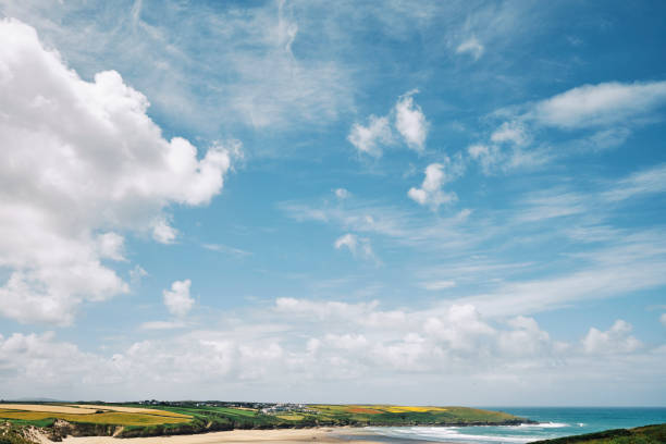 Views over Crantock Beach, Newquay, Cornwall from Pentire on a sunny June day. Views of the wild poppy fields in the far distance.