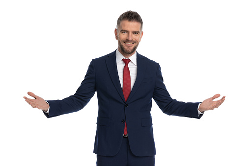 attractive businessman greeting us with open arms and a wide smile on his face against white background