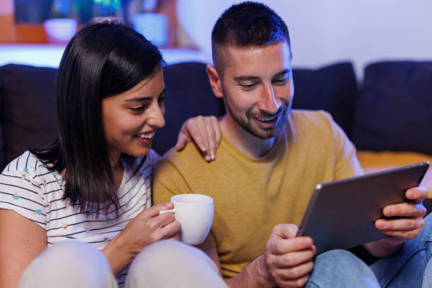 istock Young couple playing games on digital tablet 1411596095