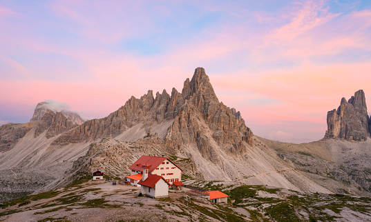 Stunning view of a mountain hut during a beautiful sunset with Mt Paterno in the background. The Three Peaks of Lavaredo are the undisputed symbol of the Dolomites, Italy.