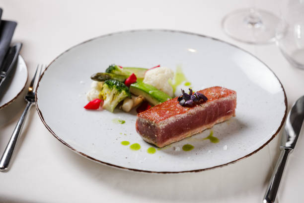 istock Tuna steak served with steamed vegetables on a plate in fine dining 1411598530