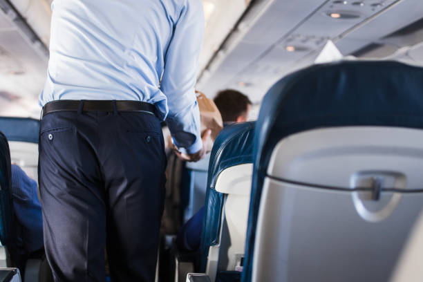 istock Flight attendant walking inside of an airplane 1411601136