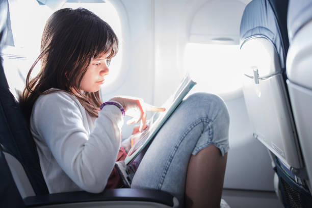 Girl reading a book at airplane