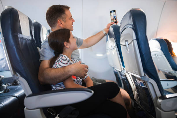 istock Father and daughter taking a selfie during airplane flight 1411601244