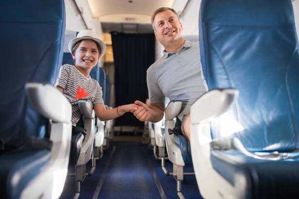 istock Happy family holding hands when travelling by airplane 1411601262