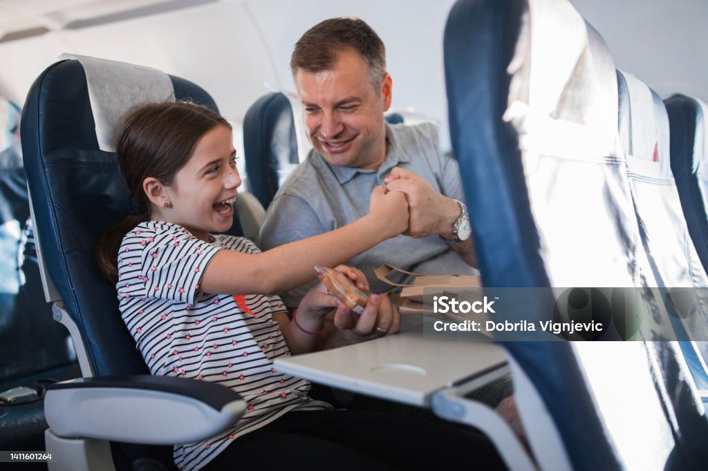 Happy father and daughter having a fist bump when sharing sandwich Smiling young girl taking a sandwich from her father's hands and fist bumping with him for fun Travel Stock Photo