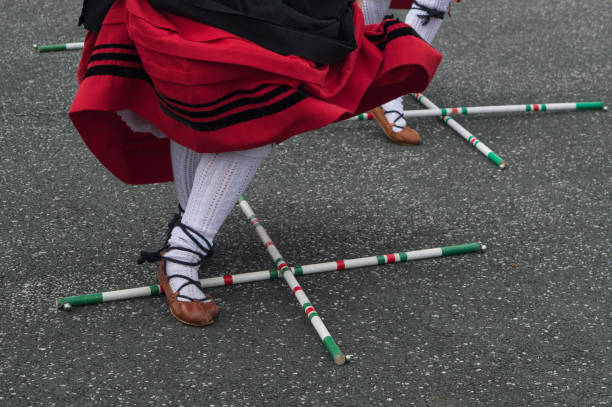 baskischer tanz in tracht mit kreuzstöcken auf dem boden - baskenland stock-fotos und bilder