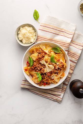 Top view of bolognese pasta on white table and cheese italian food