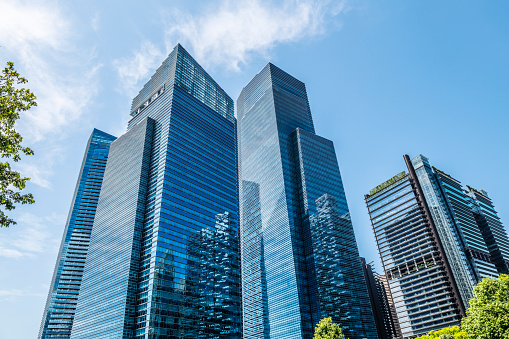 Business woman at the financial district with beautiful skyscrapers on the background during the morning light in Paris. Wide panoramic view