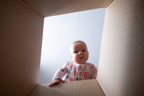 istock Happy baby into parcel cardboard box and smiling. 1411605825