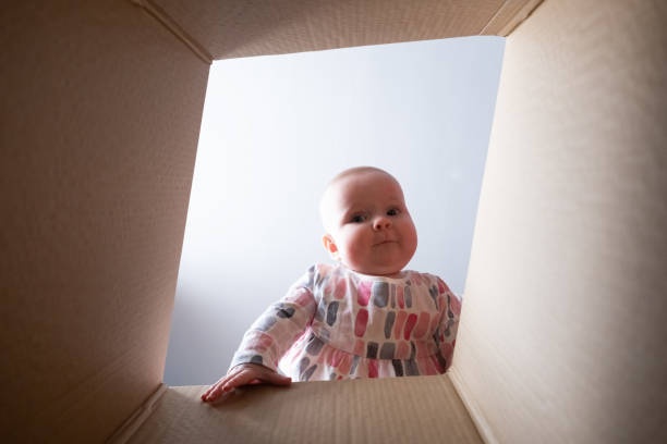 istock Happy baby into parcel cardboard box and smiling. 1411605839