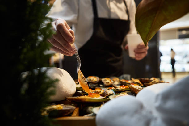 waiter adding sauce on mussels during catering waiter adding sauce on mussels during catering yummy stock pictures, royalty-free photos & images