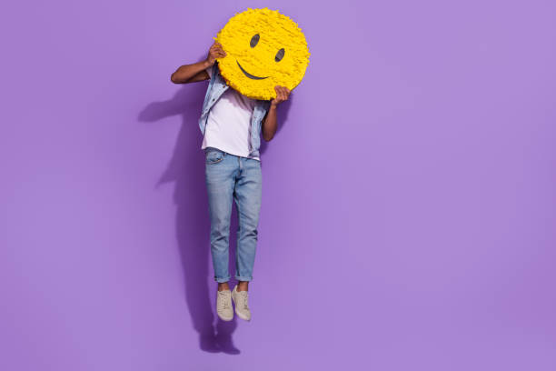 foto de cuerpo entero de hombre alegre positivo usa jeans saltando espacio vacío sosteniendo sonrisa piñata aislada color violeta fondo - smiley face smiling sign people fotografías e imágenes de stock