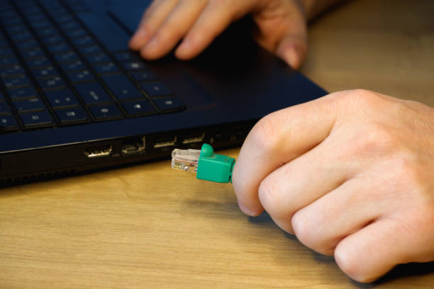 istock A man hand connects an RJ45 network connector to a laptop. 1411611591