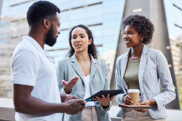 istock A diverse group of entrepreneurs using a tablet and talking outside on a balcony. Young employees brainstorm creative ideas and discussing a plan and a strategy during a break outside a work building 1411611603