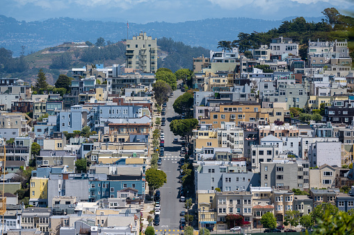 A steep city street surrounded by idyllic residential houses in downtown San Francisco, California, USA.