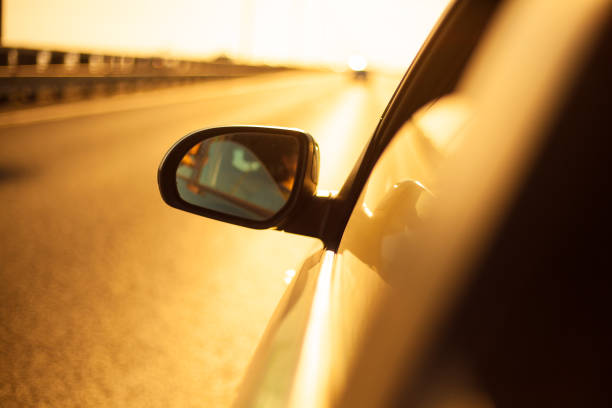 istock view outside the window from car driving at sunset (bokeh, blurred, golden hour). 1411613754