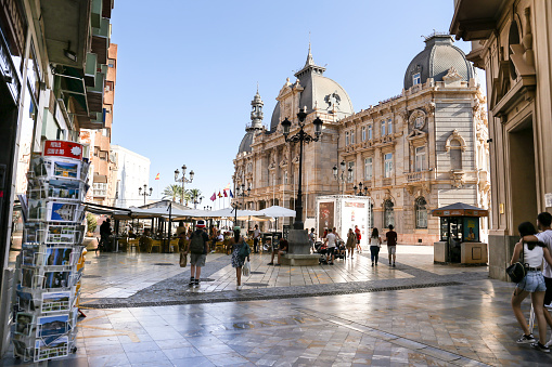 Cartagena, Murcia, Spain- July 17, 2022: Beautiful piazza and colossal town hall of Cartagena city on a sunny day of summer