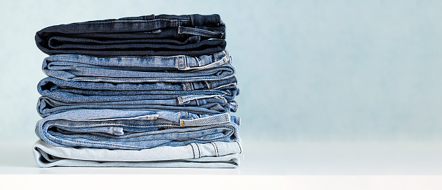 Some stacked blue jeans, close up. Denim collection.