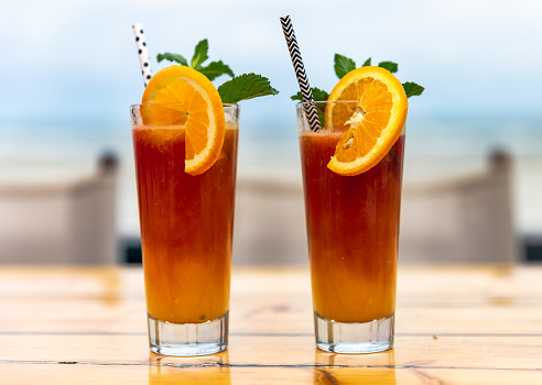 Glass of orange juice at a cafe by the beach