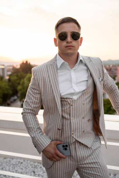 istock Elegant handsome man posing on the rooftop during sunset 1411628436