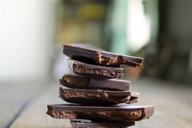 istock Dark chocolate with filling. a wooden table and a stack of chocolate. A stack of chocolate slices on a wooden table. chocolate slide. 1411628482
