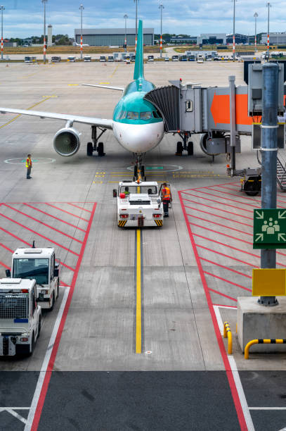 personale di terra che gestisce un aeromobile commerciale in un aeroporto - passenger boarding bridge foto e immagini stock