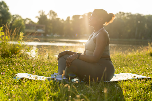 African American woman practicing meditating at the park
